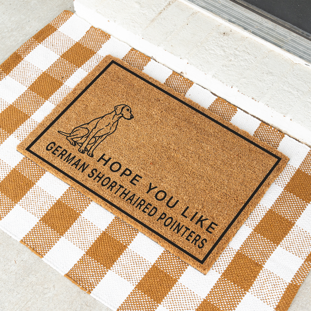 Hope You Like German Shorthaired Pointers coir doormat with a drawing of a sitting German shorthaired pointer at an angle on a tan and white check rug