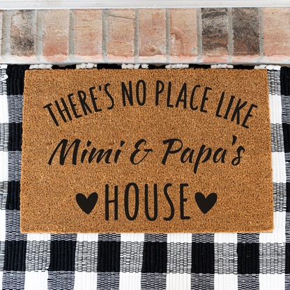 There's No Place Like Mimi & Papa's House coir doormat on a black and white buffalo check rug, close view