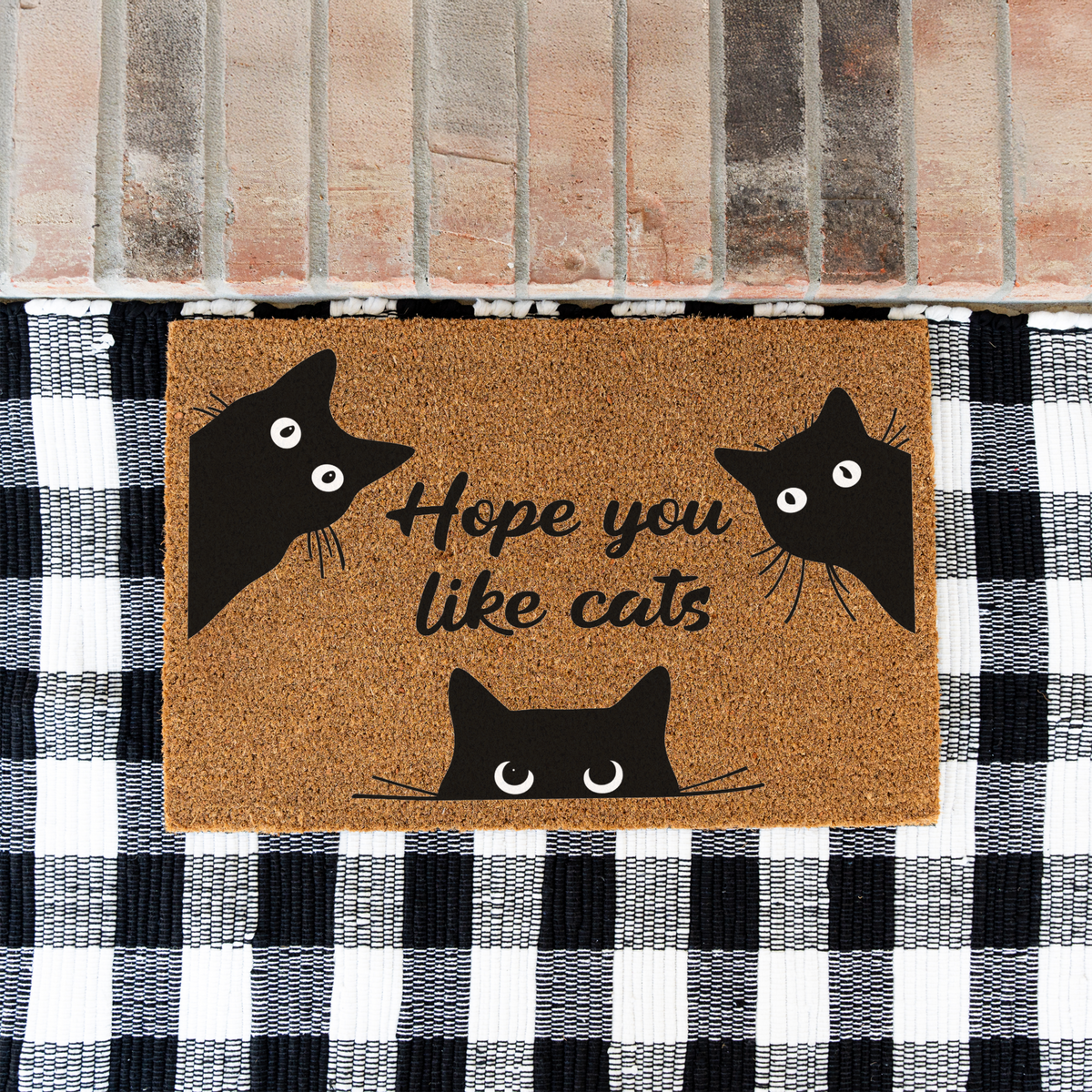 Hope You Like Cats coir doormat with three peeking black cats on a black and white buffalo check rug at a brick step