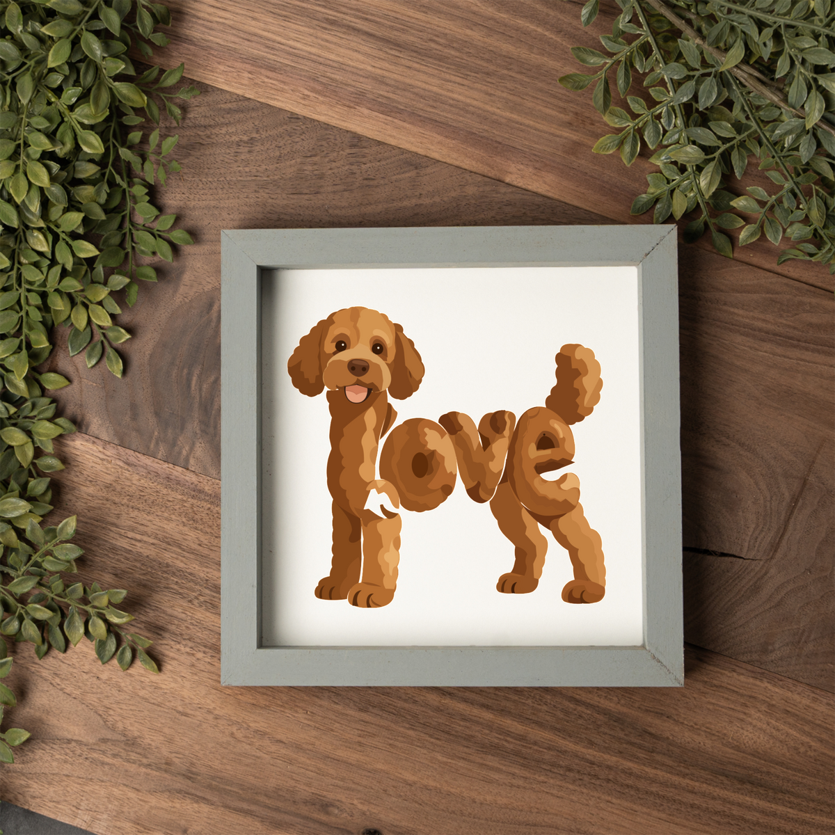 Standing red doodle love square framed sign with a grey frame on a dark wood table with greenery