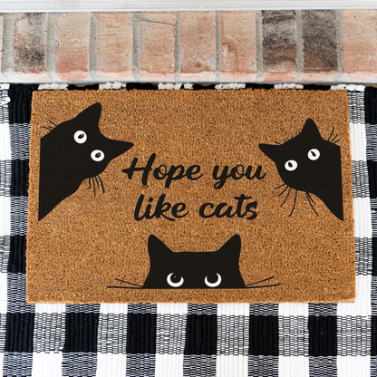 Hope You Like Cats coir doormat with three peeking black cats on a black and white buffalo check rug, close view