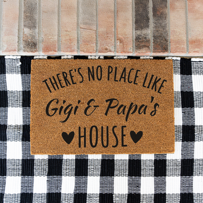 There's No Place Like Gigi & Papa's House coir doormat on a black and white buffalo check rug at a brick step