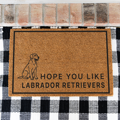 Hope You Like Labrador Retrievers coir doormat with a drawing of a sitting Labrador retriever on a black and white buffalo check rug, close view