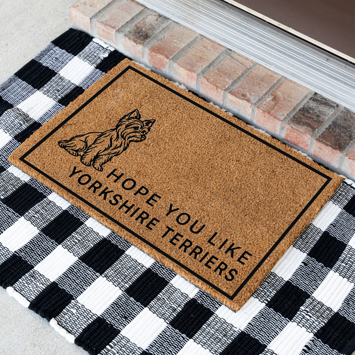 Hope You Like Yorkshire Terriers coir doormat with a drawing of a sitting Yorkshire terrier at an angle on a black and white buffalo check rug