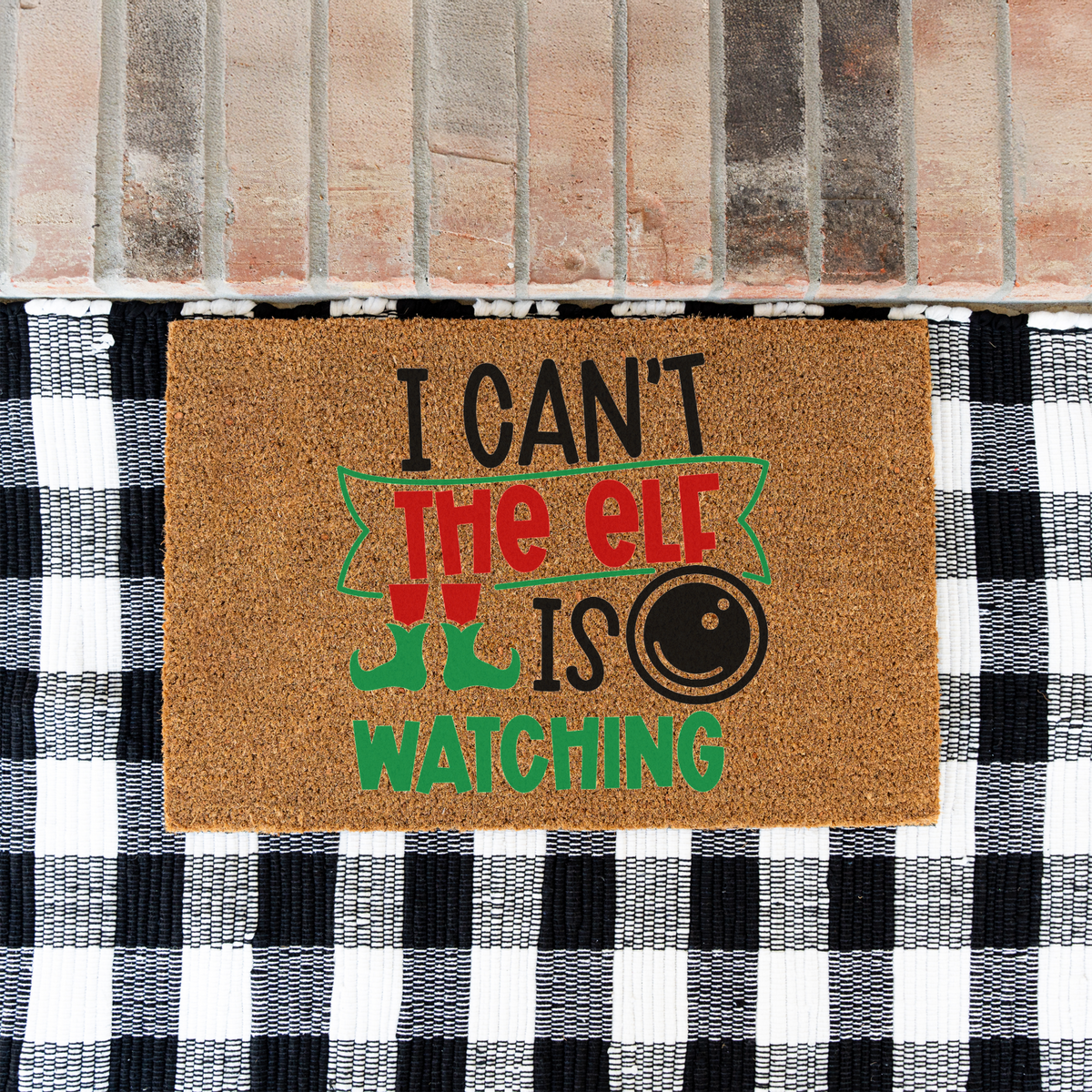 I Can't The Elf Is Watching coir doormat on a black and white buffalo check rug at a brick step
