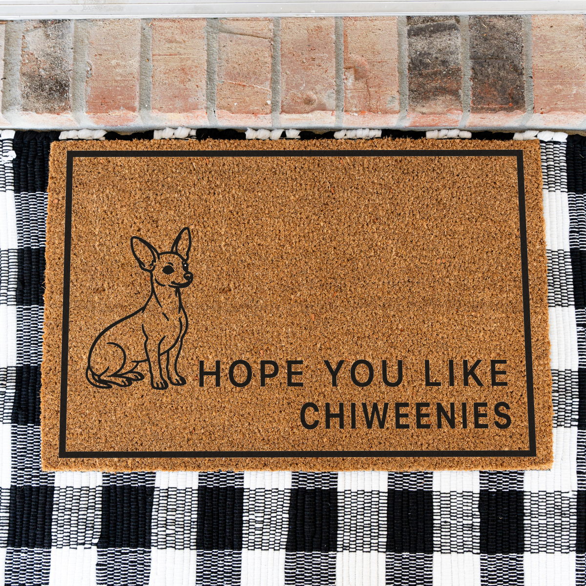 Hope You Like Chiweenies coir doormat with a drawing of a sitting Chiweenie on a black and white buffalo check rug, close view