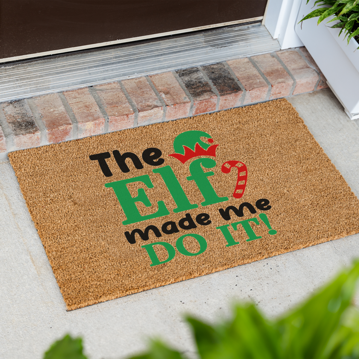 The Elf Made Me Do It coir doormat at an angle in front of a brick step
