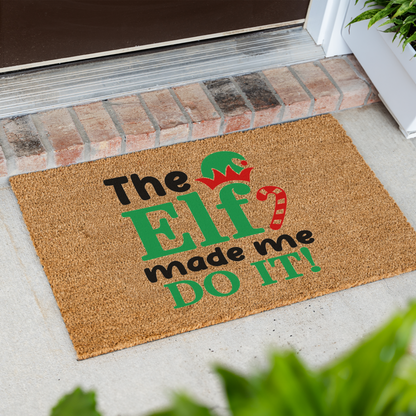 The Elf Made Me Do It coir doormat at an angle in front of a brick step