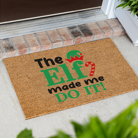 The Elf Made Me Do It coir doormat at an angle in front of a brick step