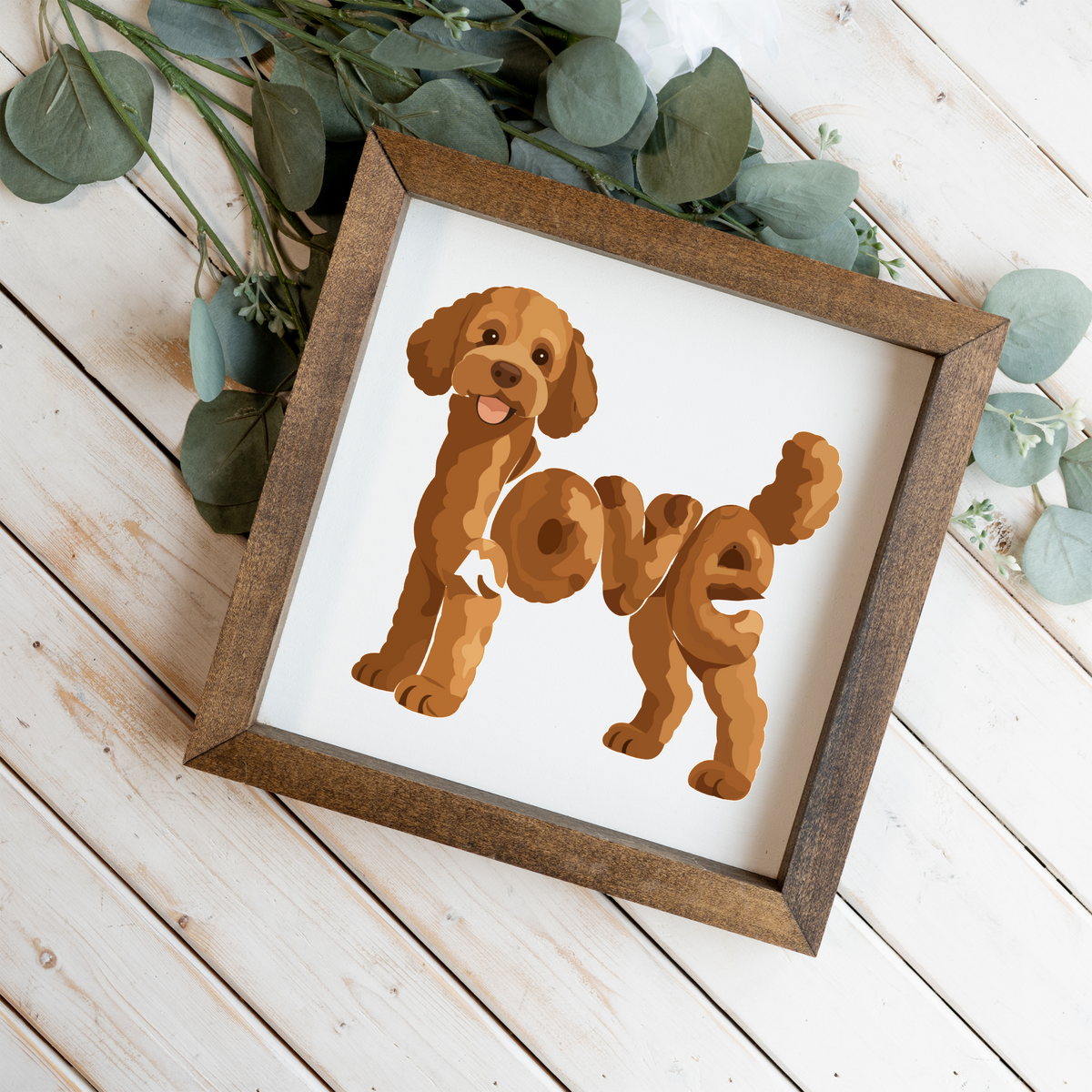 Standing red doodle love square framed sign with a walnut frame on white wood planks with eucalyptus