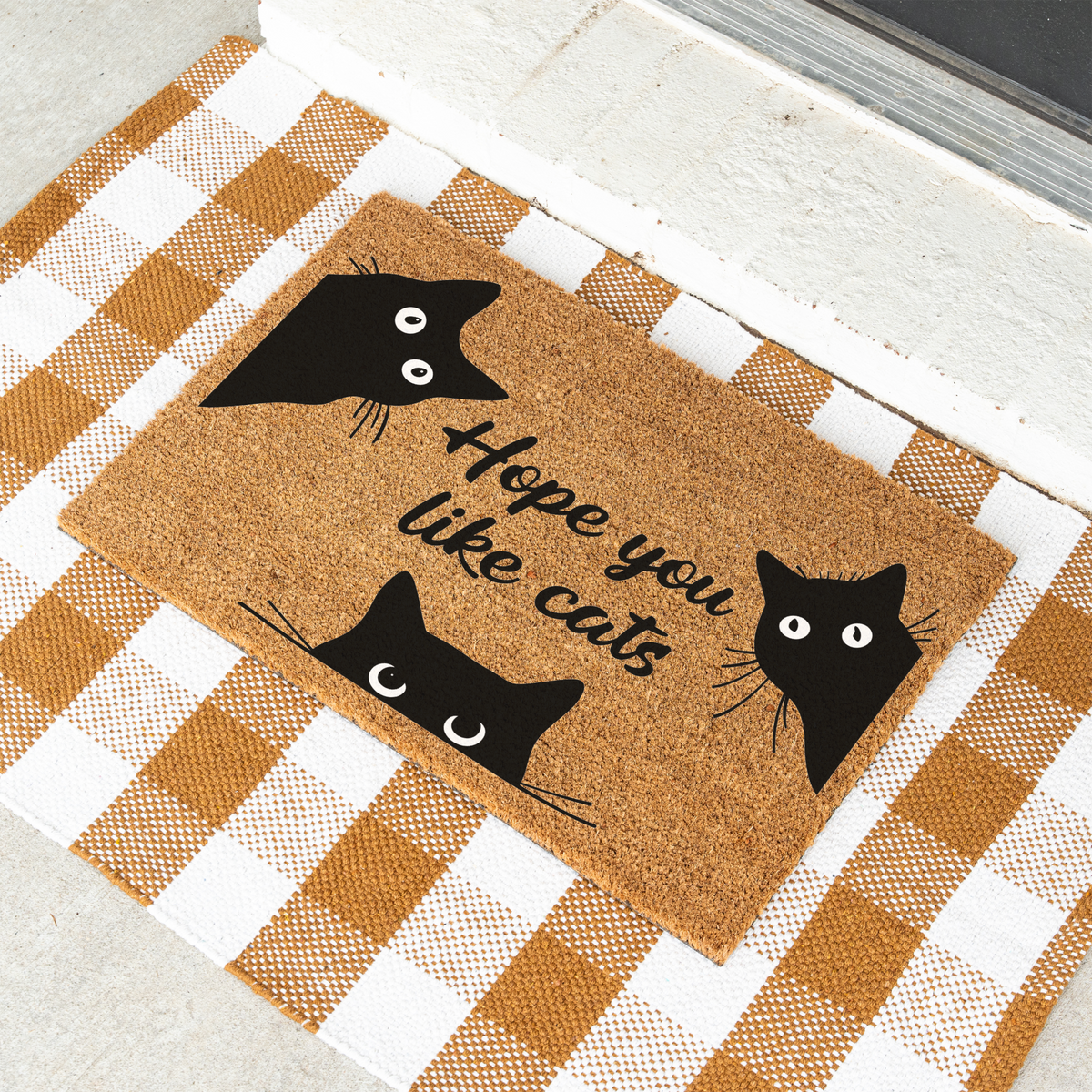 Hope You Like Cats coir doormat with three peeking black cats at an angle on a tan and white check rug