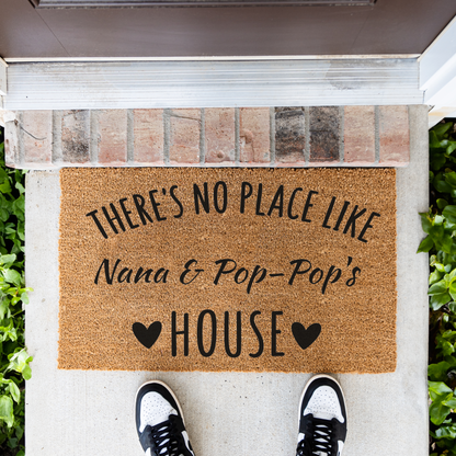 There's No Place Like Nana & Pop-Pop's House coir doormat in front of a brick step, top-down view