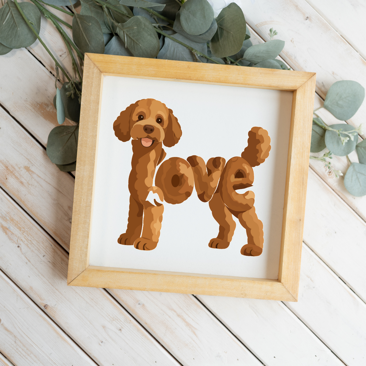 Standing red doodle love square framed sign with a natural wood frame on white wood planks with eucalyptus