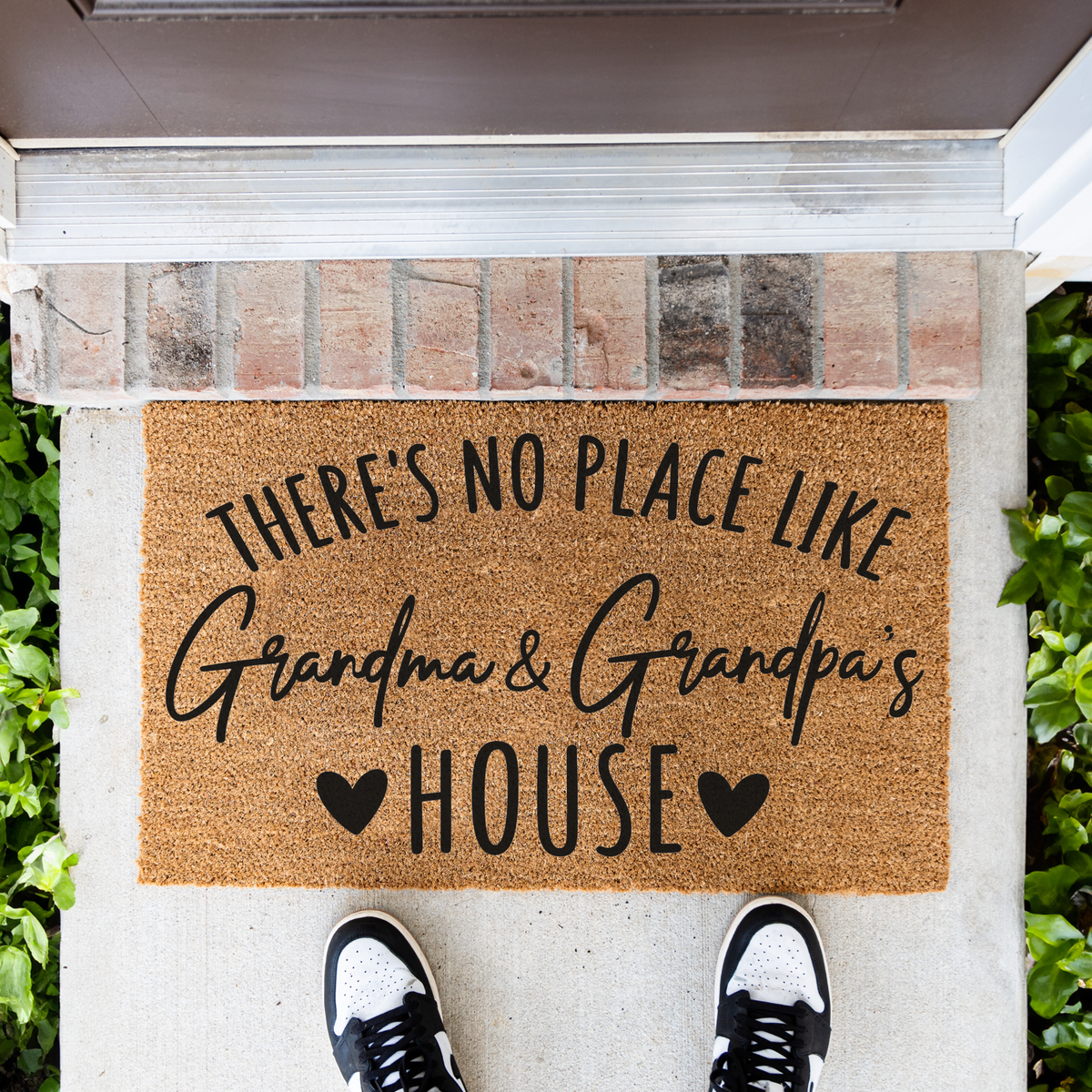 There's No Place Like Grandma & Grandpa's House coir doormat in front of a brick step, top-down view