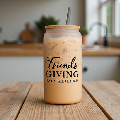 Friendsgiving 16 oz frosted glass can with a bamboo lid and straw, filled with iced coffee, on a kitchen counter