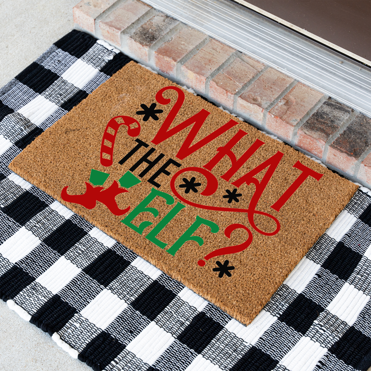What The Elf coir doormat at an angle on a black and white buffalo check rug