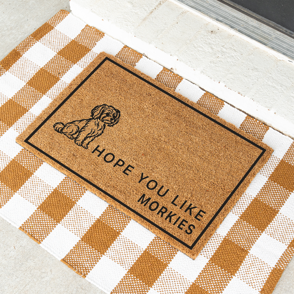 Hope You Like Morkies coir doormat with a drawing of a sitting Morkie at an angle on a tan and white check rug