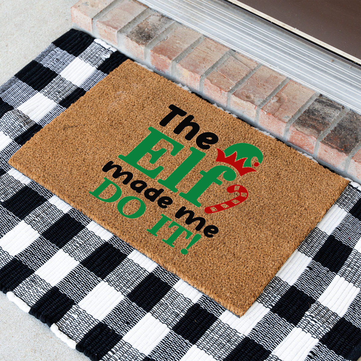 The Elf Made Me Do It coir doormat at an angle on a black and white buffalo check rug
