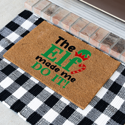 The Elf Made Me Do It coir doormat at an angle on a black and white buffalo check rug