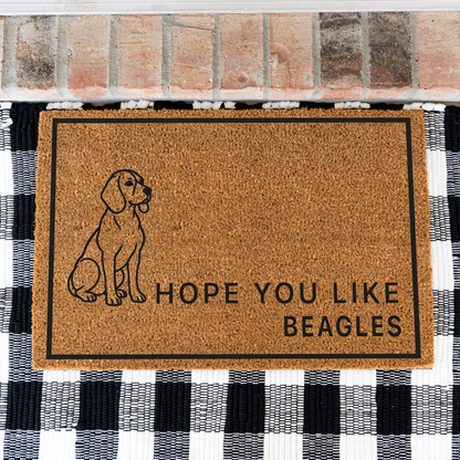 Hope You Like Beagles coir doormat with a drawing of a sitting beagle on a black and white buffalo check rug, close view
