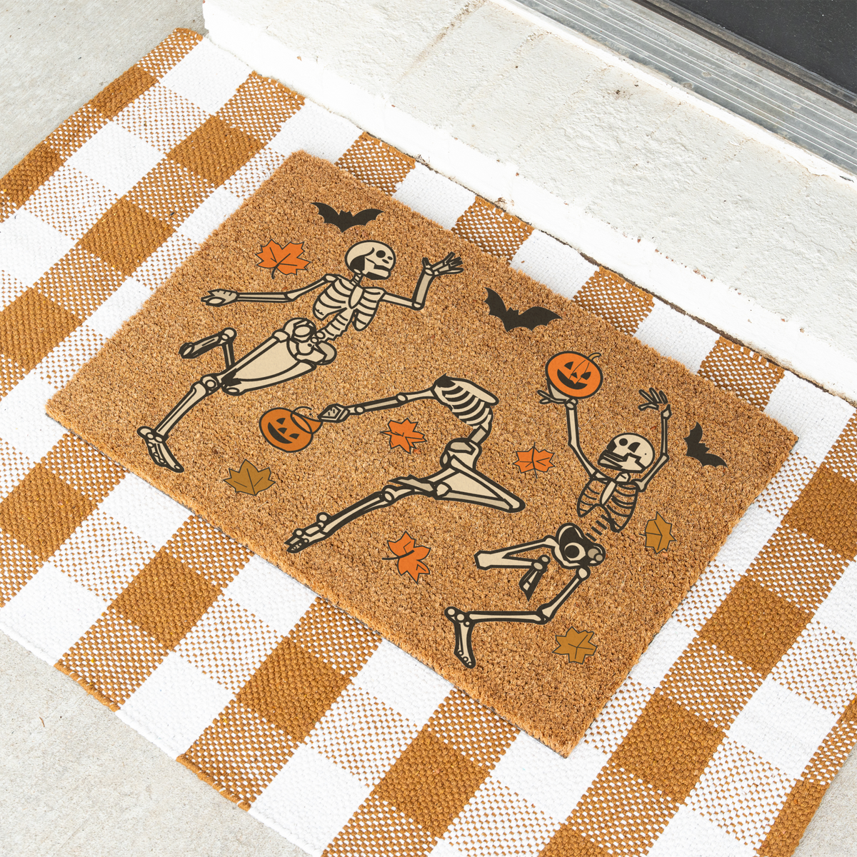 Dancing skeletons Halloween coir doormat on a tan and white check rug
