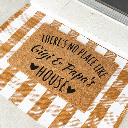 There's No Place Like Gigi & Papa's House coir doormat on a tan and white check rug