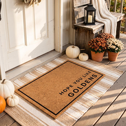 Hope You Like Goldens minimalist coir doormat on a striped jute rug on a styled fall porch