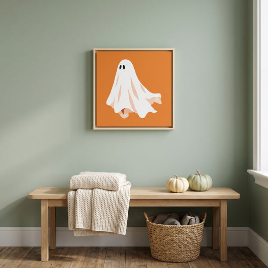 Orange ghost framed canvas print, 20 x 20 inch size, hanging above a wood entry bench on a sage green wall
